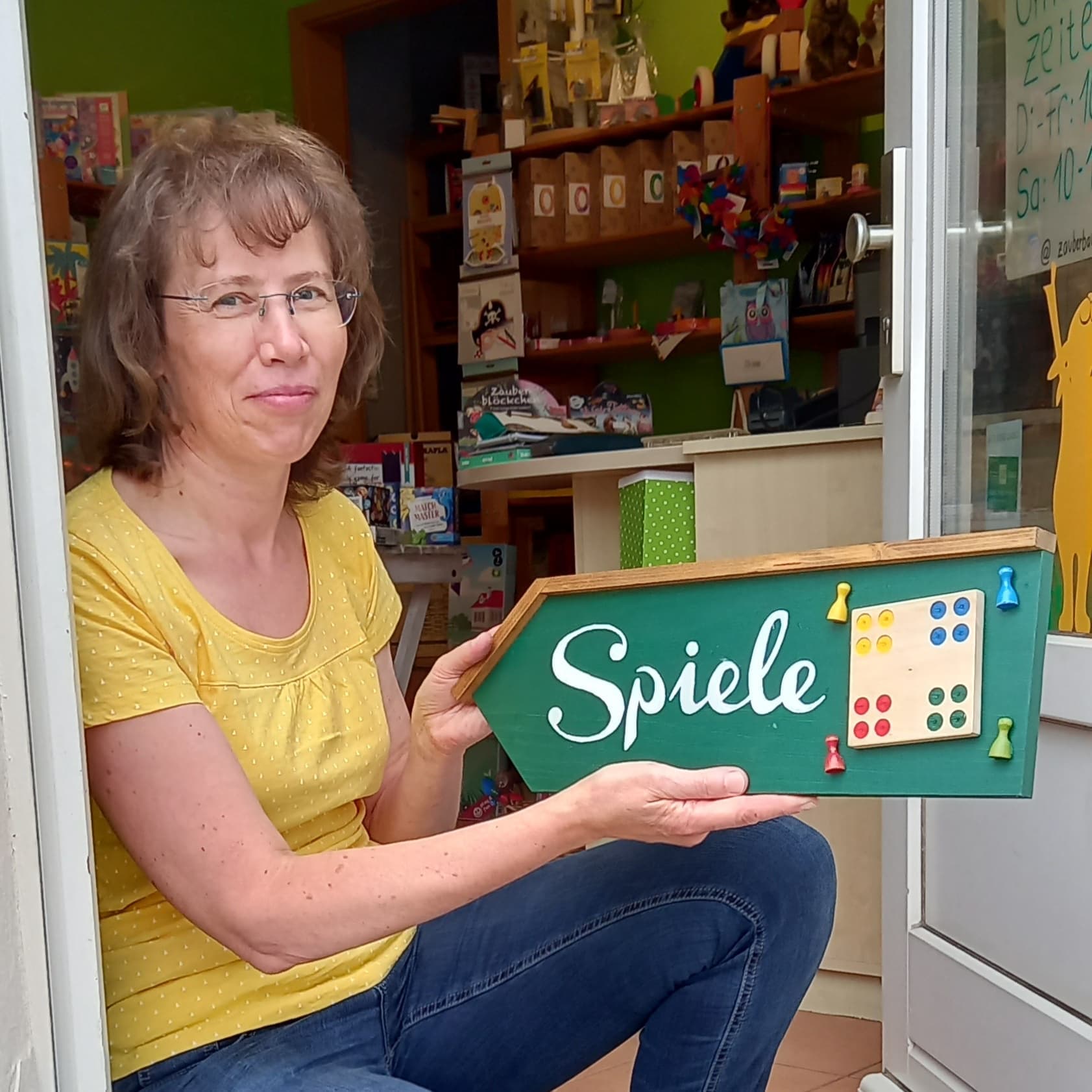 Foto Kathrin Dostlebe mit Spiele-Schild