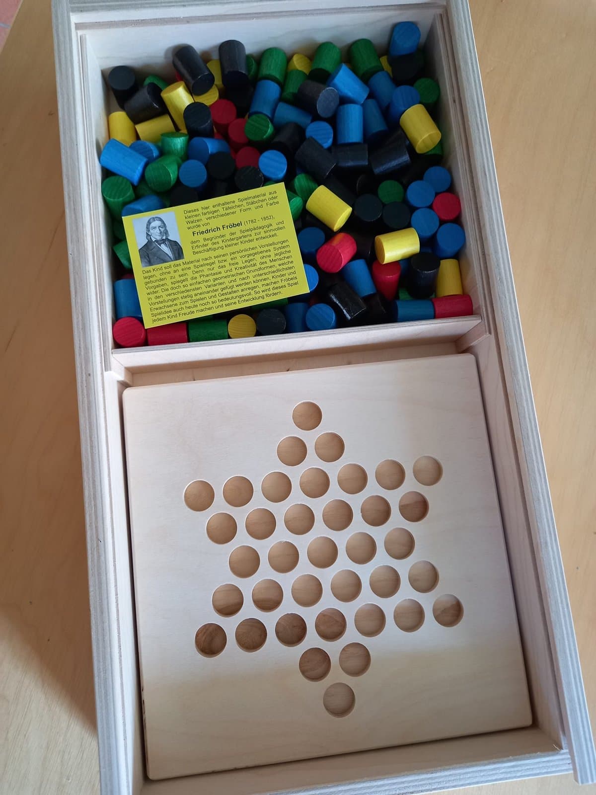 Fröbel-Spielmaterial: bunte Kacheln und Steckbrett